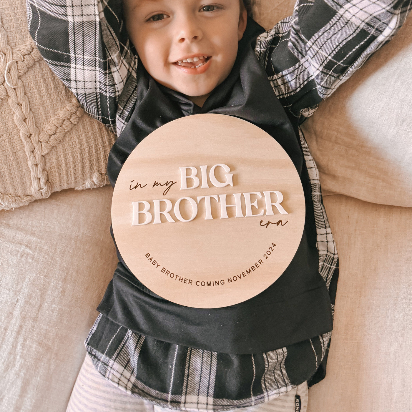 Adorable child holding wooden big brother announcement