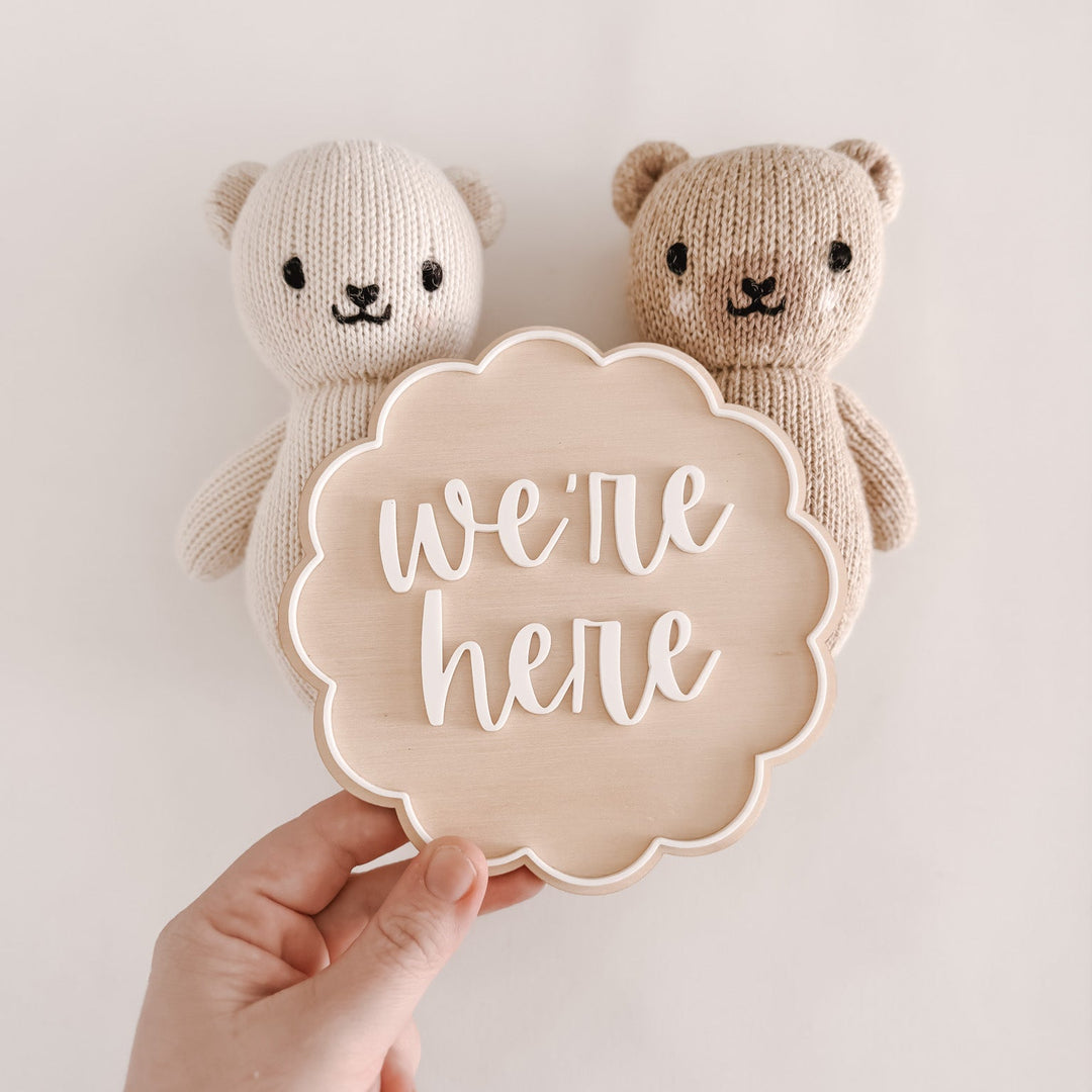 Two knitted bear toys with a sign saying &