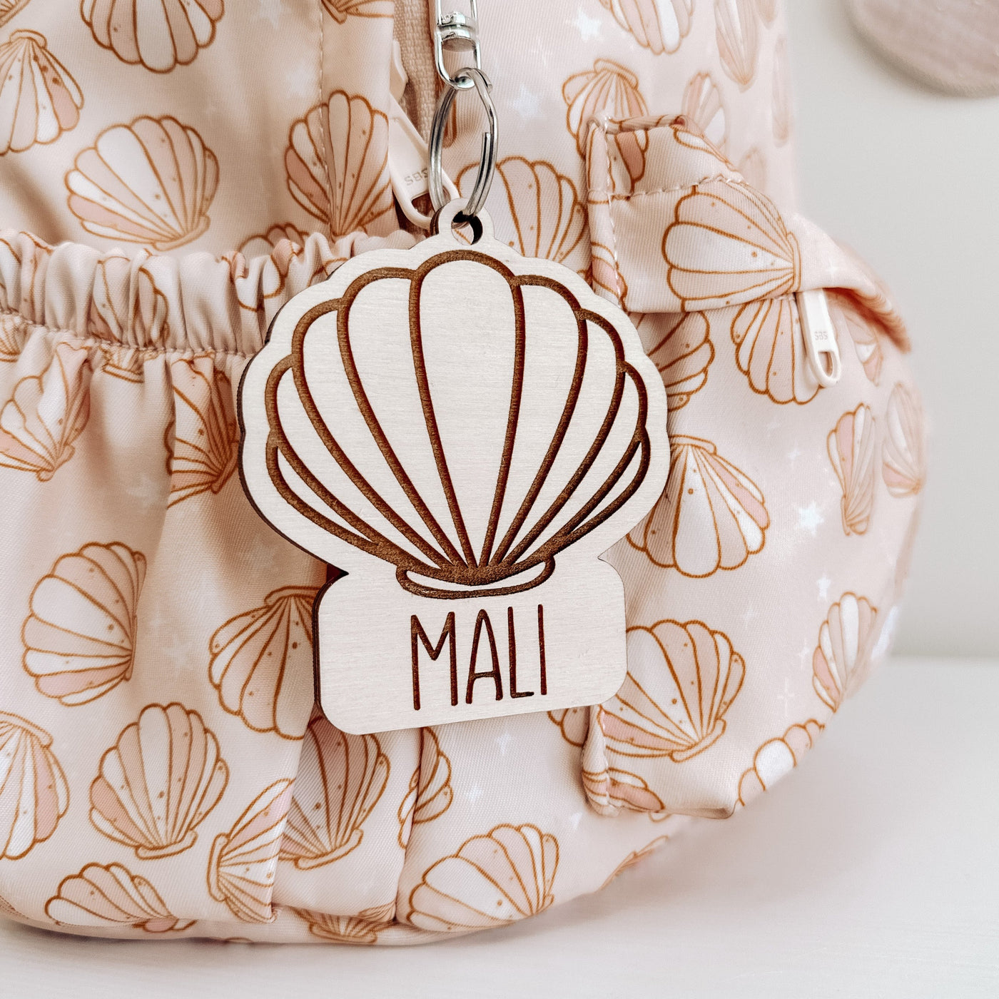 Wooden shell bag tag hanging on a shell backpack